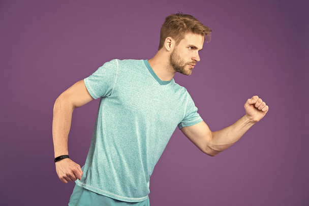 Man in tshirt and shorts on violet background. Runner in blue casual clothes on purple background. Sportsman in active wear for running. Sport fashion style and trend. Fitness and gym activity - 写真・画像