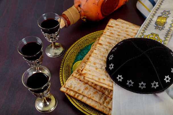 Pessach und rote koschere Gläser Wein mit einer Matza Haggada auf einem Vintage-Holz-Hintergrund - Foto, Bild