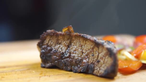 warme gegrilde biefstuk van de BBQ-lendenstuk, plantaardige salade en saus op cutting Board close-up. - Video