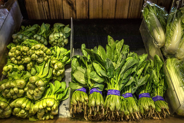 Légumes naturels sur le comptoir du marché. Bok Choy, chou blanc chinois (gauche) et épinards (droite)
) - Photo, image