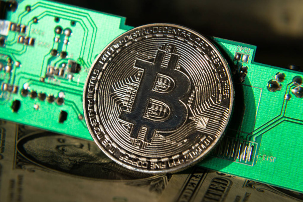 Moeda de prata bitcoin com dólares e placa-mãe de computador, mineração criptomoeda e conceito de investimento
 - Foto, Imagem