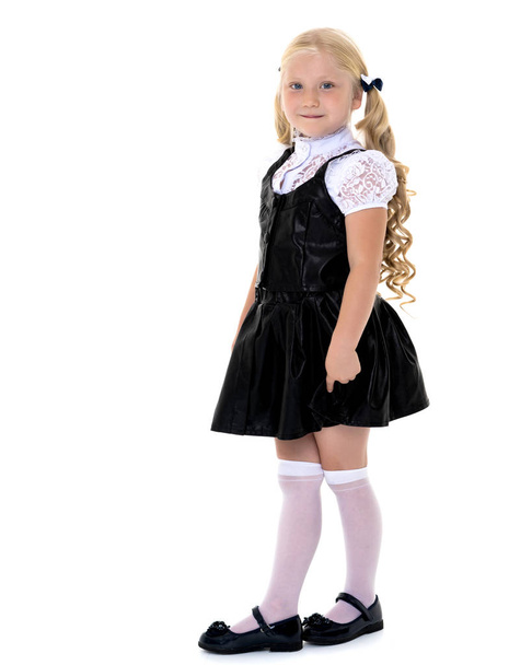 Beautiful little girl in a school uniform. - Foto, afbeelding