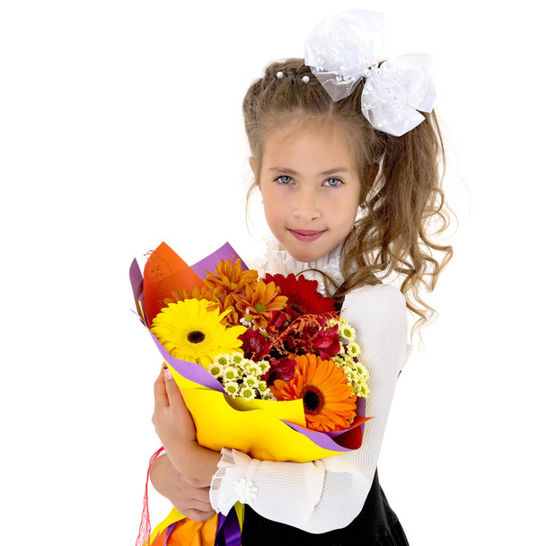 Little girl with a bouquet of flowers - Фото, изображение