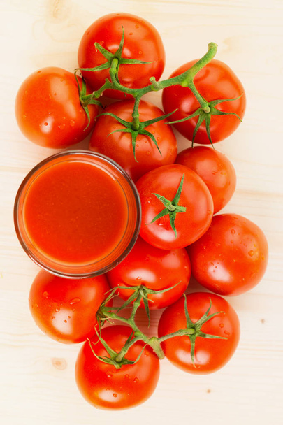 Стакан томатного сока с помидорами на деревянном фоне, концепция здорового образа жизни. Вид сверху
. - Фото, изображение