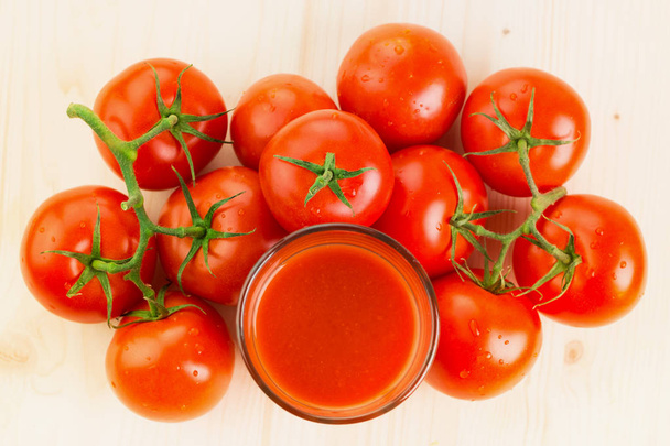 Стакан томатного сока с помидорами на деревянном фоне, концепция здорового образа жизни. Вид сверху
. - Фото, изображение