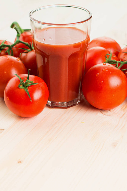 Vaso de jugo de tomate con tomates sobre fondo de madera, concepto de estilo de vida saludable. Copiar espacio para texto
. - Foto, Imagen