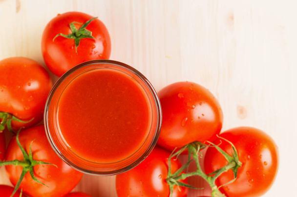 Szklankę soku pomidorowego z pomidorami na podłoże drewniane, pojęcie zdrowego stylu życia. Kopiować miejsca na tekst. Od góry. - Zdjęcie, obraz