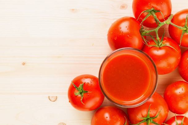 Стакан томатного сока с помидорами на деревянном фоне, концепция здорового образа жизни. Копировать место для текста. Вид сверху
. - Фото, изображение