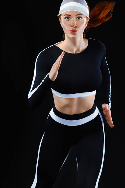 Strong athletic woman sprinter, running on black background wearing in sportswear. Fitness and sport motivation. Run concept with copy space. - Фото, изображение