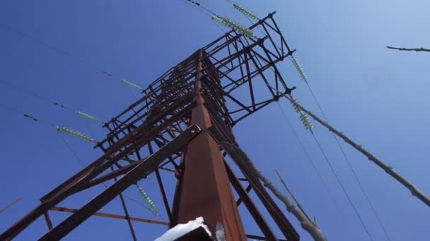 Opwaartse weergave diagonaal naar de lijn van de macht en de pyloon tegen een blauwe hemel met wolken - Video