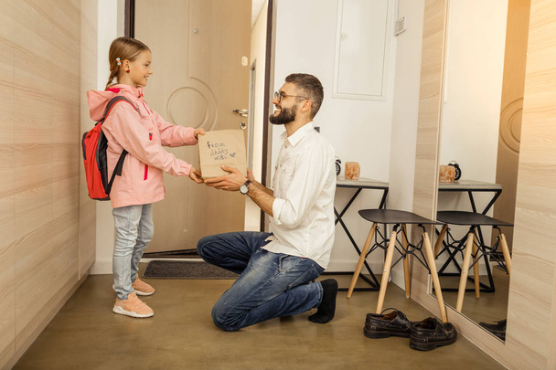 Tall bearded dark-haired father giving a gift to his daughter - Foto, Bild