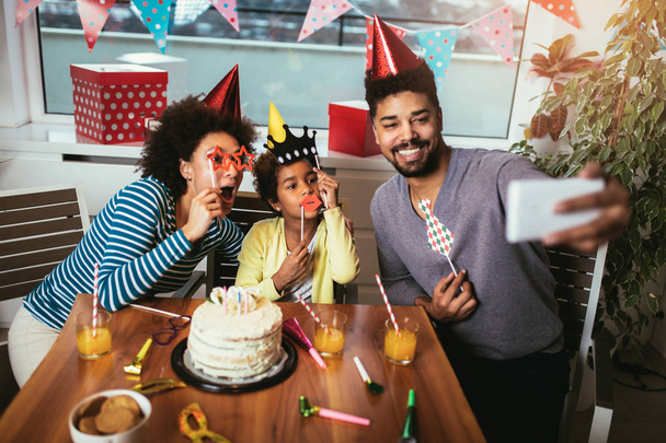 Happy family celebrating a birthday together at home make selfie - Photo, Image