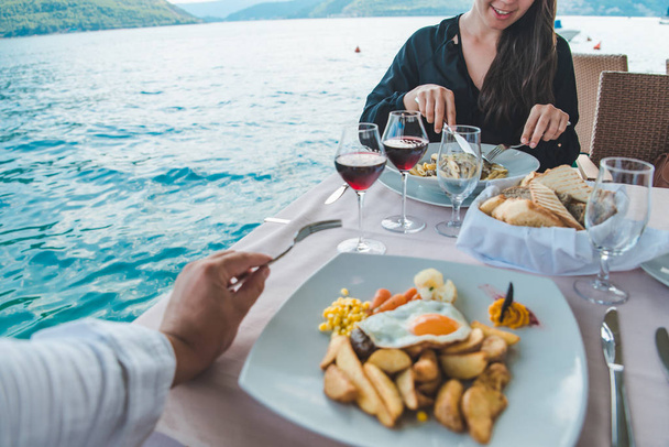 pareja comiendo en el restaurante en la playa. Una cita romántica. vacaciones de verano
 - Foto, Imagen