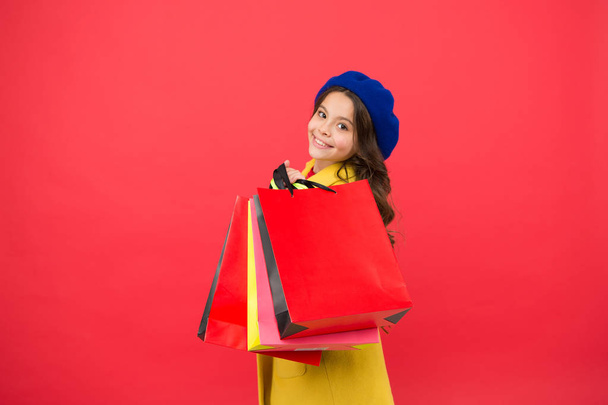 Girl cute kid hold shopping bags. Get discount shopping on birthday holiday. Nice purchase. Fashionista enjoy shopping. Customer satisfaction. Prime time buy spring clothing. Obsessed with shopping - Foto, immagini