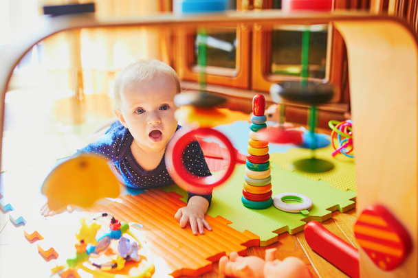 Baby girl playing with toys on the floor. Happy healthy little child at home - Foto, imagen