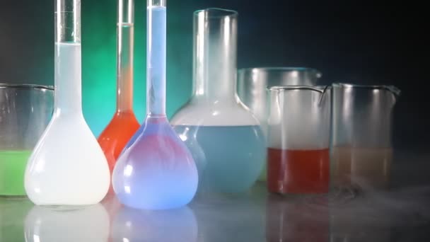 Eczane ve kimya teması. Araştırma laboratuarında çözeltisi olan cam deney şişesi. Bilim ve tıbbi geçmiş. Koyu renk arkaplan üzerinde laboratuvar test tüpleri, bilimsel araştırma ekipmanları konsepti - Video, Çekim