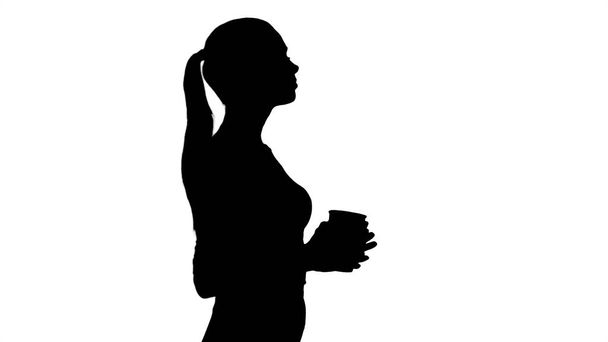 Silueta Relajado elegante mujer de negocios beber café caminando. - Foto, Imagen