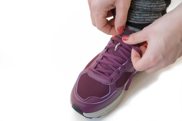 жінка зав'язує шнурки в кросівки ізольовані на білому. концепція запуску
 - Фото, зображення