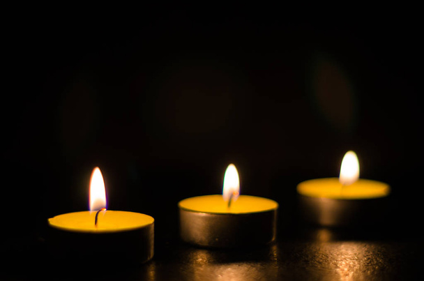 Burning scented candles isolated on a black background. - Foto, Imagen