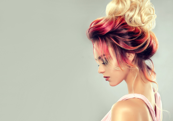 Красива дівчина-модель з елегантною багатокольоровою зачіскою. Стильна жінка з підсвічуванням кольору волосся моди. Творче червоне і рожеве коріння, модна забарвлення
. - Фото, зображення