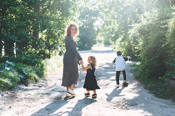 Une femme marche avec ses enfants sur la route
 - Photo, image