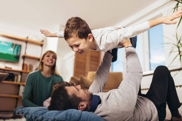 Šťastná rodina baví na podlaze v obýváku doma, smíchem, Selektivní ostření. - Fotografie, Obrázek