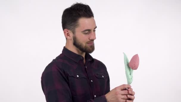 Όμορφος γενειοφόρος άνδρας ρομαντικά κρατώντας λουλούδι παιχνίδι στην κάμερα - Πλάνα, βίντεο