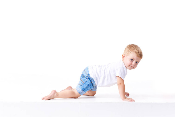 Cute boy plaing with toy car on floor, isolated on white - Foto, immagini