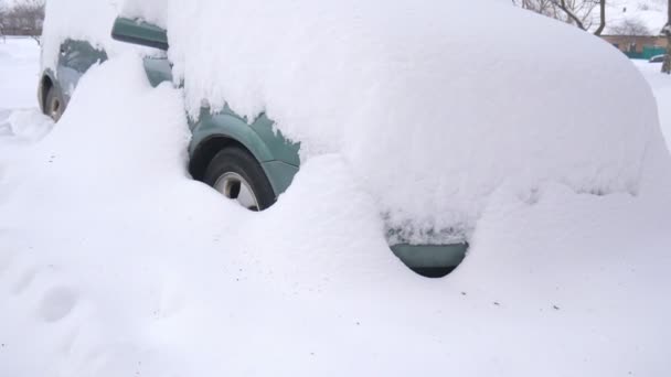 Samochód, pokryte śniegiem, w burzy ciężka zima. Samochody na podwórku pod śniegiem. - Materiał filmowy, wideo