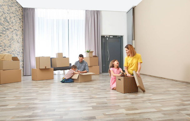 Family unpacking cardboard boxes in their new house. Moving day - Foto, Imagem
