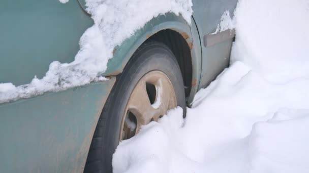 Samochód, pokryte śniegiem, w burzy ciężka zima. Samochody na podwórku pod śniegiem. - Materiał filmowy, wideo