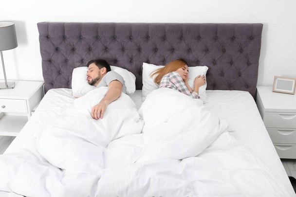 Couple with relationship problems ignoring each other in bedroom - Foto, afbeelding