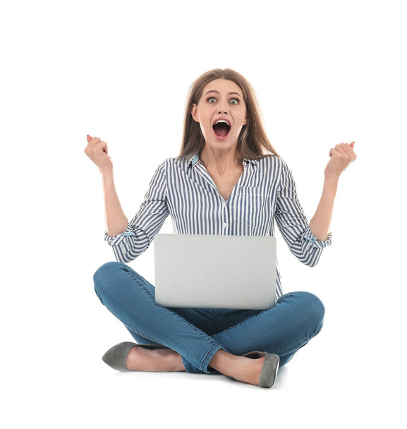 Emotional young woman with laptop celebrating victory on white background - Photo, Image
