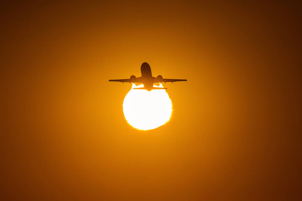 силует повітряного літака над сонцем з красивими червоними хмарами на фоні
 - Фото, зображення