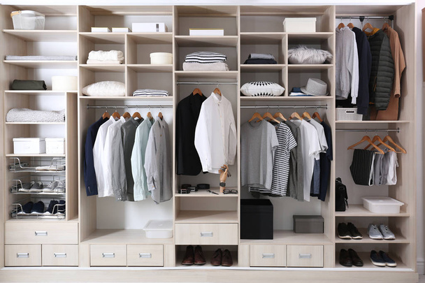 Stylish clothes, shoes and home stuff in large wardrobe closet - Fotó, kép