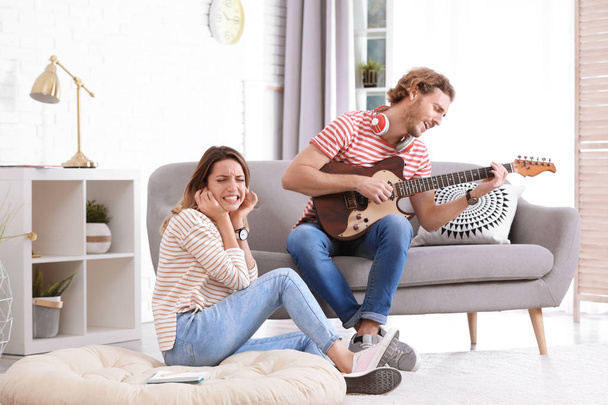 Young man playing electric guitar in living room. Space for text - Fotoğraf, Görsel