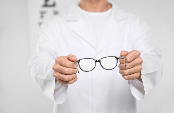Male ophthalmologist with eyeglasses in clinic, closeup - Фото, зображення