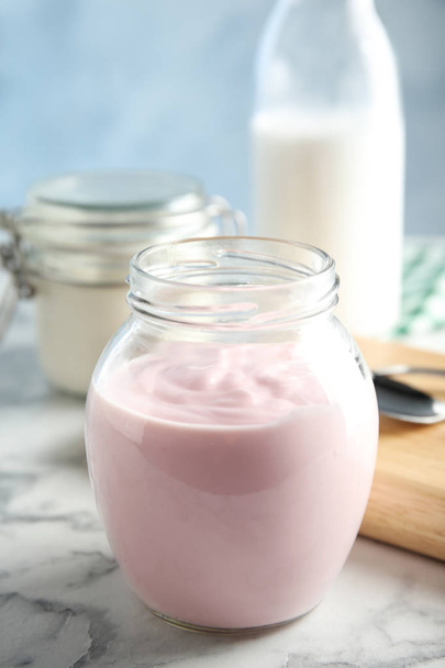 Glass jar of fresh yogurt on table - Foto, Imagen