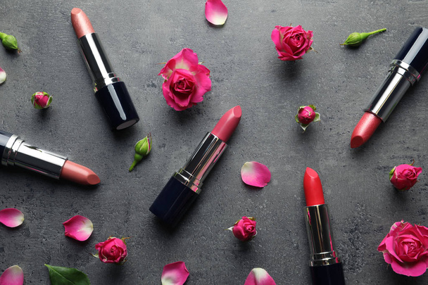 Flat lay composition with lipsticks and roses on grey background - Photo, image