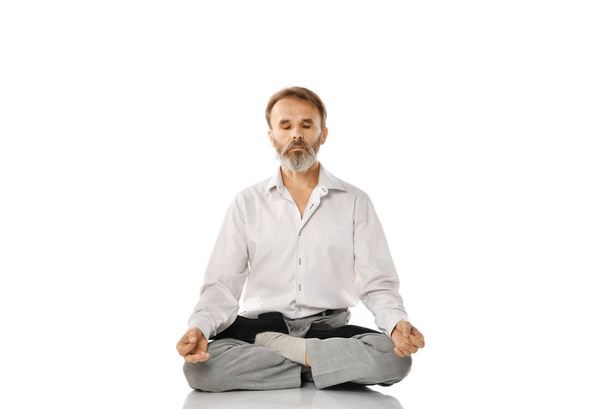 Senior bearded old man practicing yoga classic asana pose isolated on white  - Valokuva, kuva
