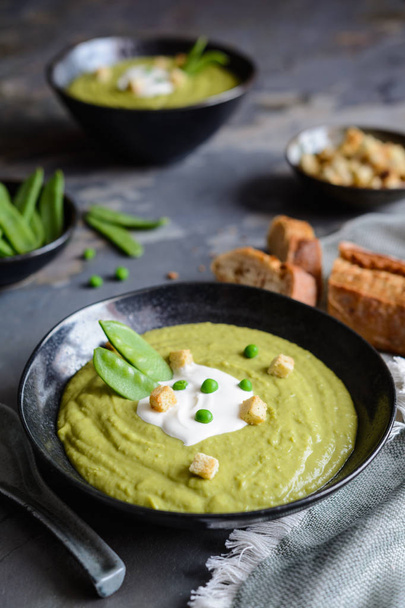 Delicious creamy green pea soup with sour cream - 写真・画像
