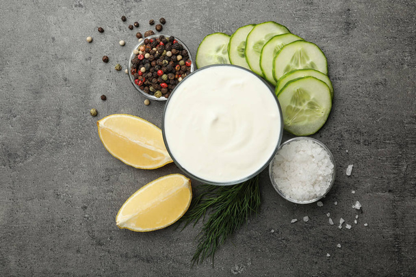 Flat lay composition with cucumber sauce and ingredients on grey background - Foto, afbeelding
