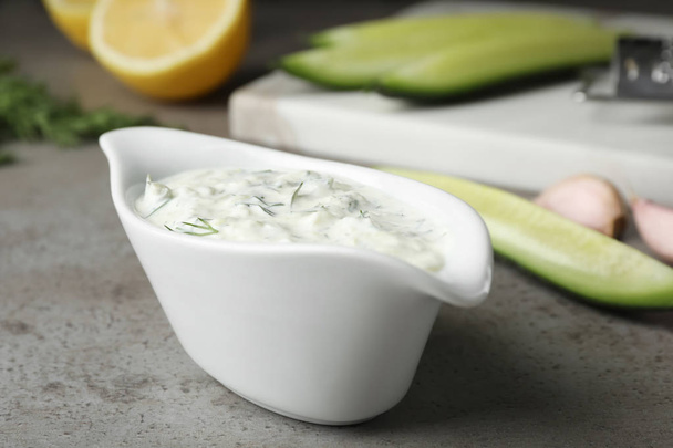 Ceramic dish of Tzatziki cucumber sauce with ingredients on table - Photo, Image