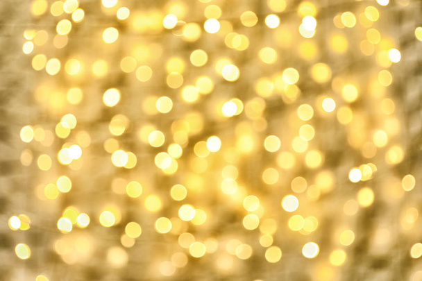 Blurred view of golden Christmas lights as background. Bokeh effect - Photo, Image