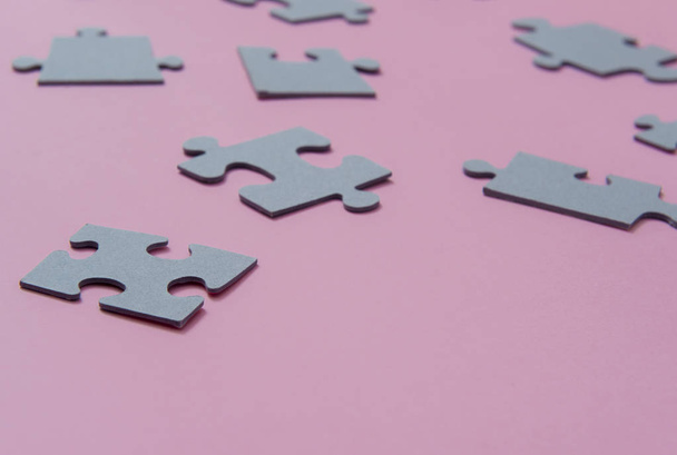 Puzzles on a pink background as a symbol of autism. Conceptual vision of the problem of autistic children - Φωτογραφία, εικόνα