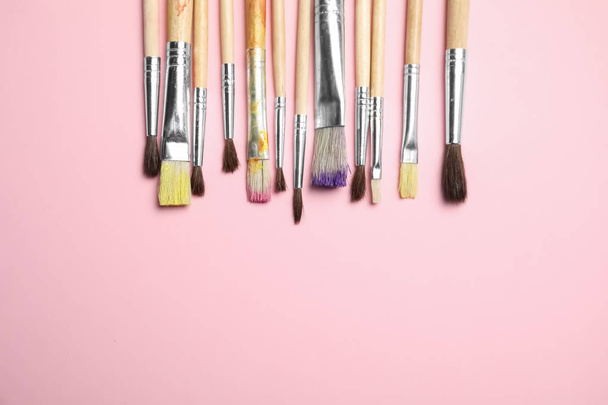 Different paint brushes on color background, top view with space for text - Photo, Image