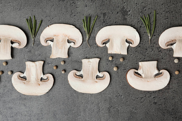 Flat lay composition of sliced fresh champignon mushrooms on gray background - Фото, изображение