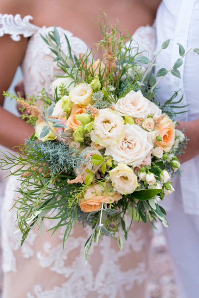 the bride is holding a rustic wedding bouquet of flowers and various herbs - Photo, Image