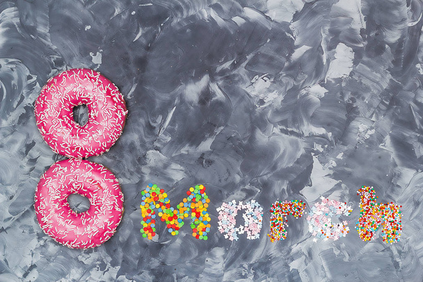 Donuts in de vorm van een figuur 8 en het woord maart van suikergoed dressing. Vrouwen dag voedsel concept. - Foto, afbeelding