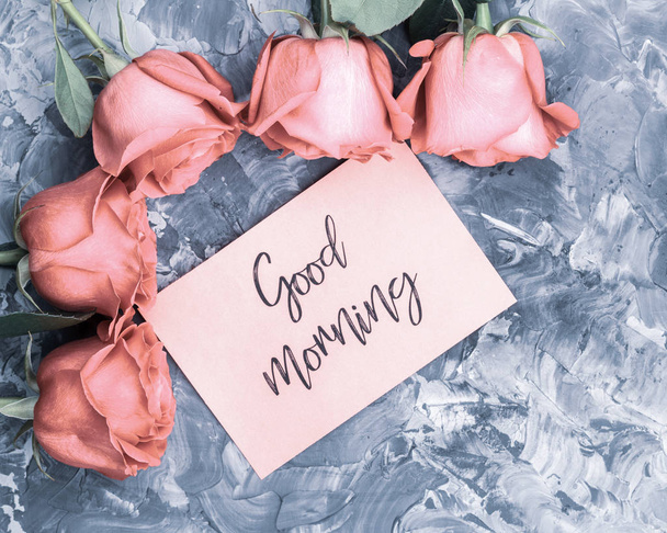 おはようございますロマンチックな概念。赤いバラとレタリングの灰色のコンクリート背景におはようを希望. - 写真・画像